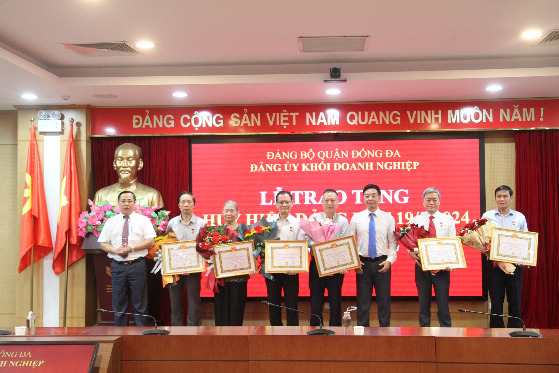 Đồng chí Vũ Mạnh Chiến và đồng chí Nguyễn Văn Quang trao và tặng hoa chúc mừng các đồng chí Đảng viên được nhận Huy hiệu 55 năm tuổi Đảng; 45 năm tuổi Đảng và 40 năm tuổi Đảng