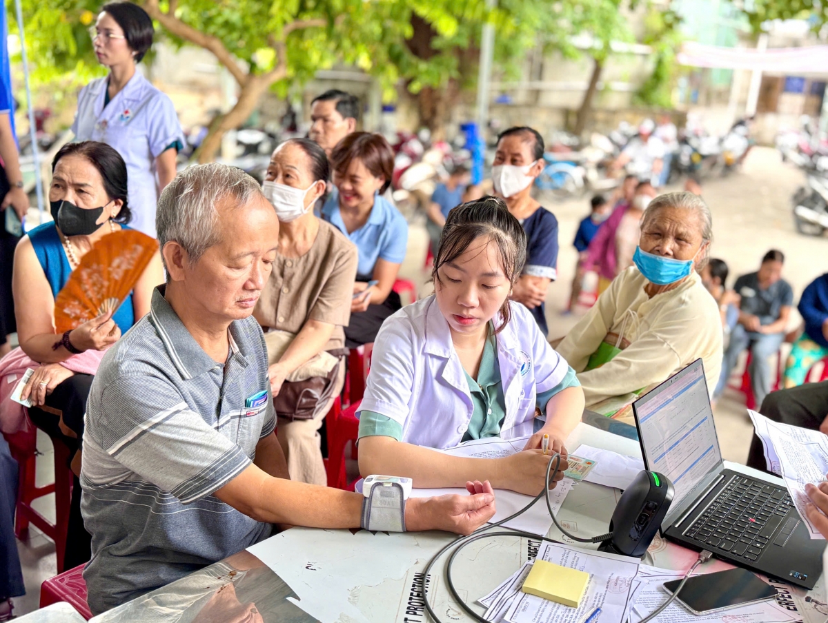 Người dân được đo huyết áp và kiểm tra các chỉ số sức khỏe ban đầu trước khi khám lâm sàng