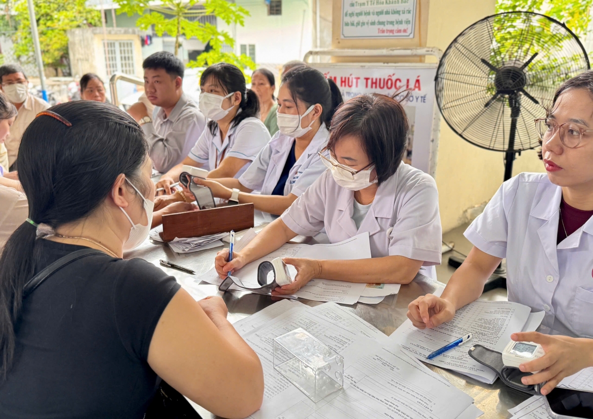 Cán bộ y tế hướng dẫn người dân làm thủ tục và lập hồ sơ khám sức khỏe điện tử